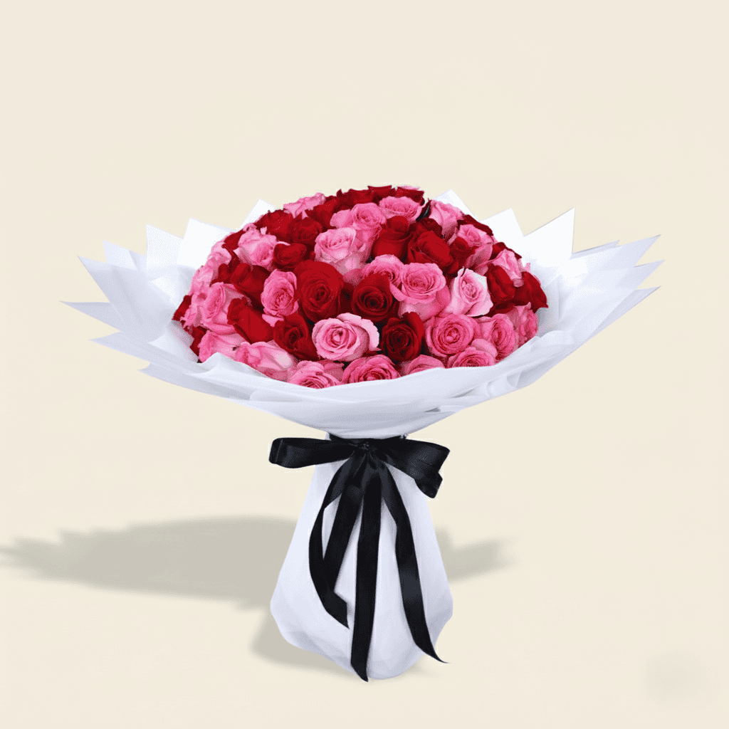 Handheld bouquet of red and pink roses in modern white wrap