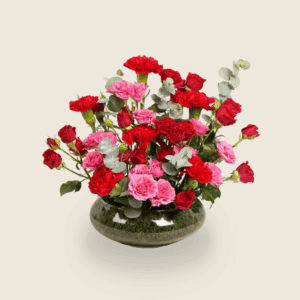 Modern round arrangement of red and pink roses with eucalyptus leaves