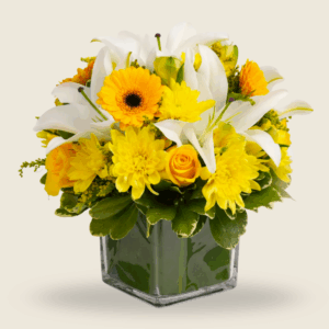 Bright yellow and white floral vase arrangement with lilies, gerberas, and roses