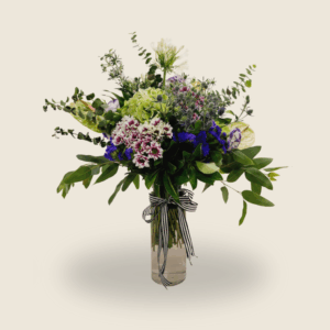 Tall green and purple vase arrangement with hydrangeas, anthuriums, and agapanthus
